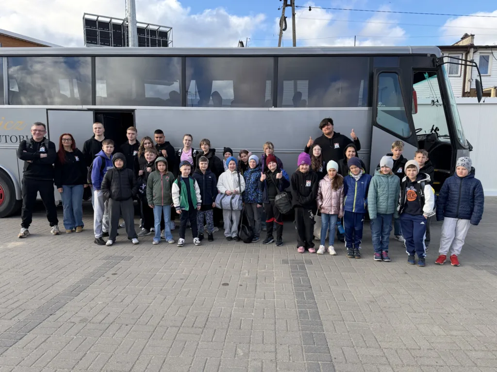 Grupa zawodników Taekwondow AZS Kutno na tle autobusu
